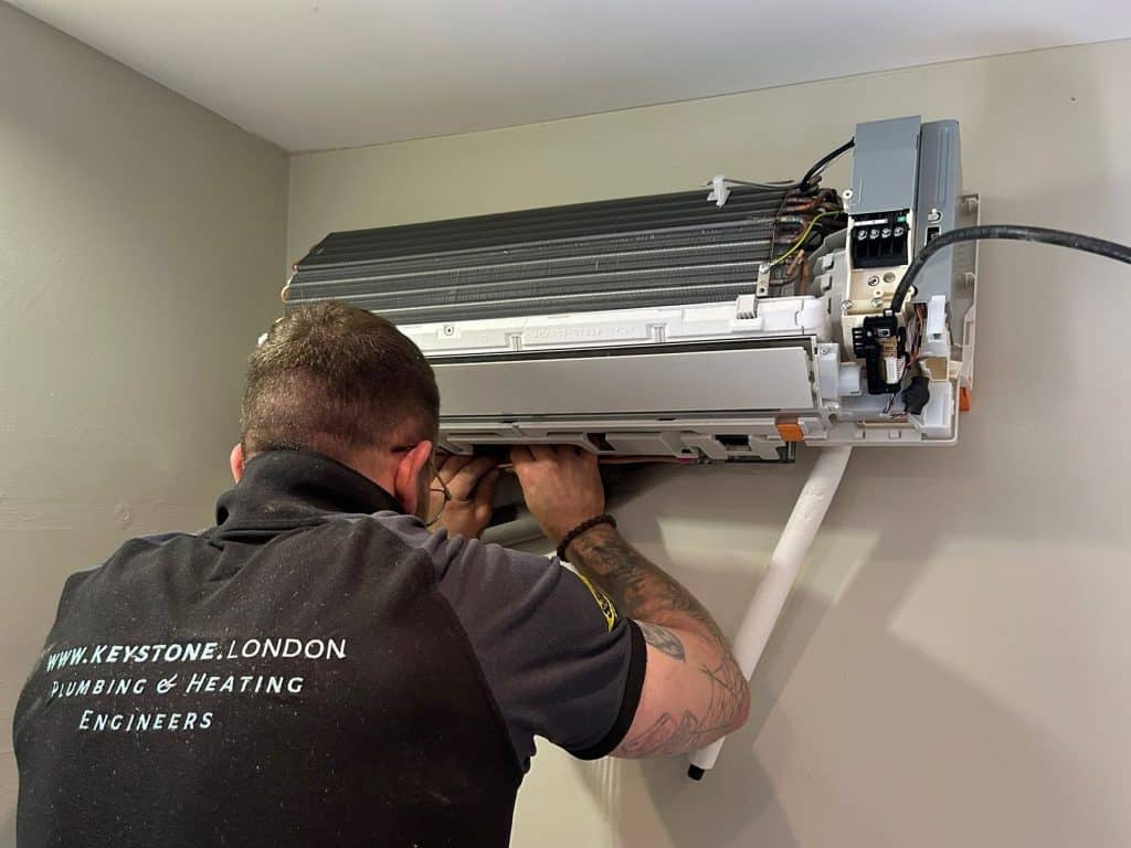 Engineer installing an indoor wall-mounted air conditioning unit