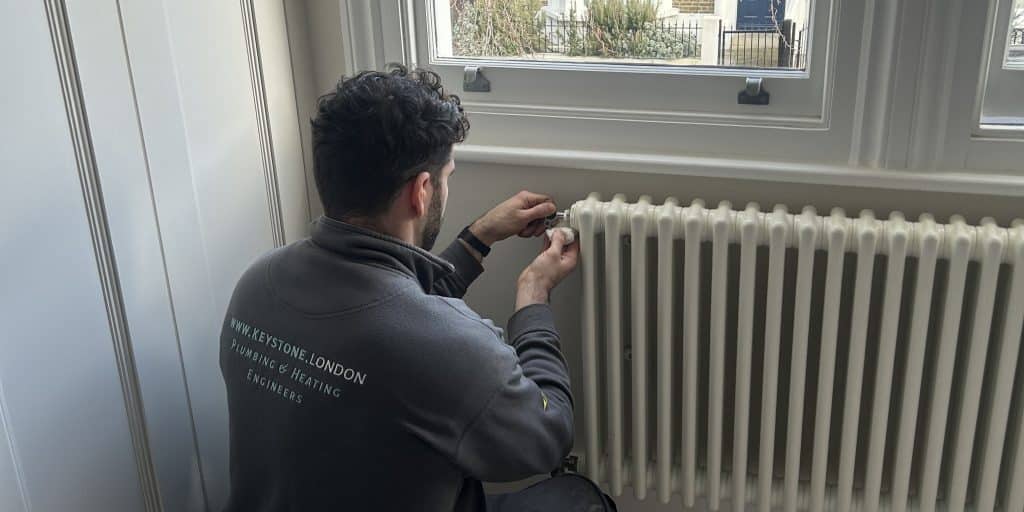 Keystone London heating engineer adjusting a radiator